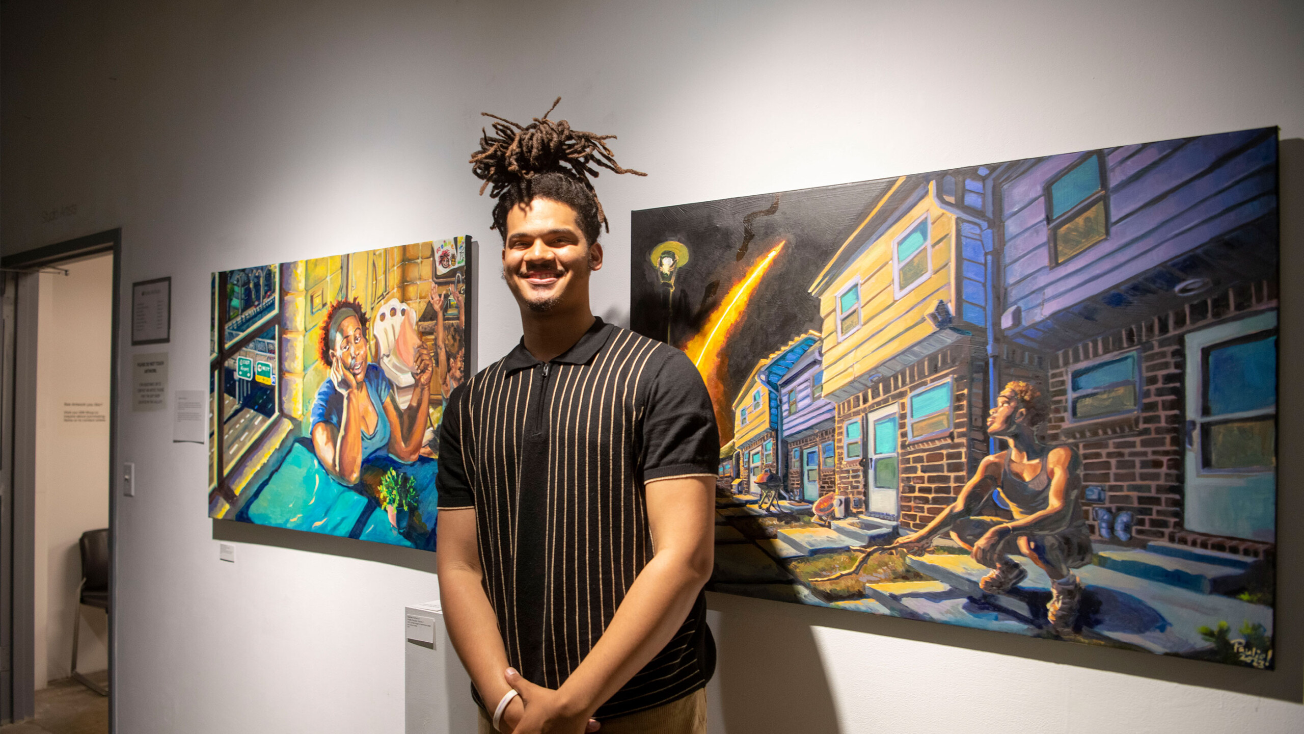 Person standing in front of vibrant urban-themed paintings in an art gallery.