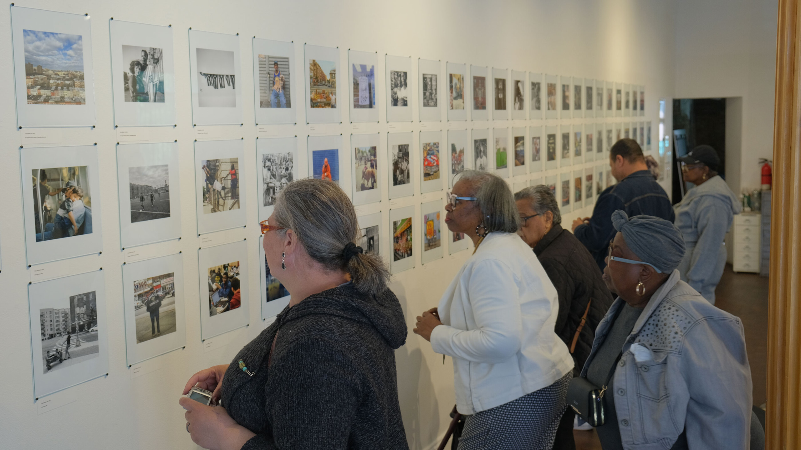 Visitors viewing photos at an art gallery exhibition.