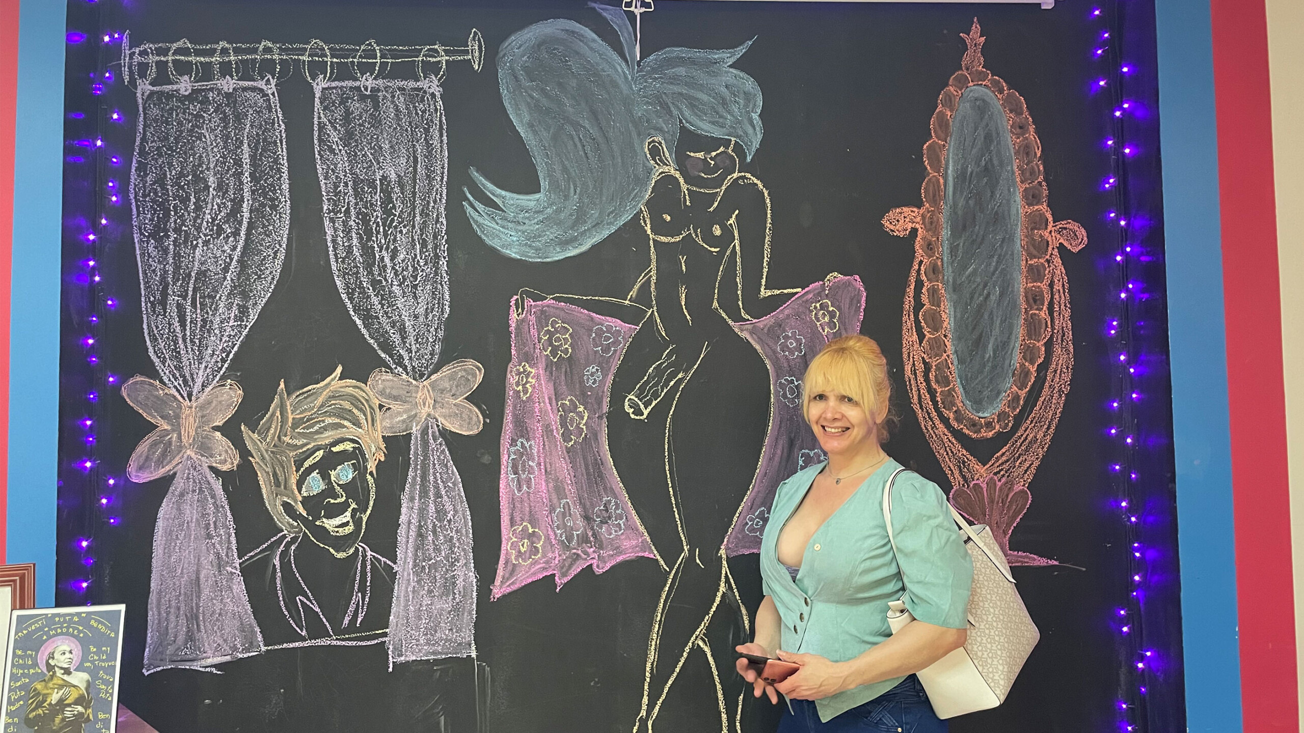 Colorful chalkboard art with a mermaid and decorative designs around a person.