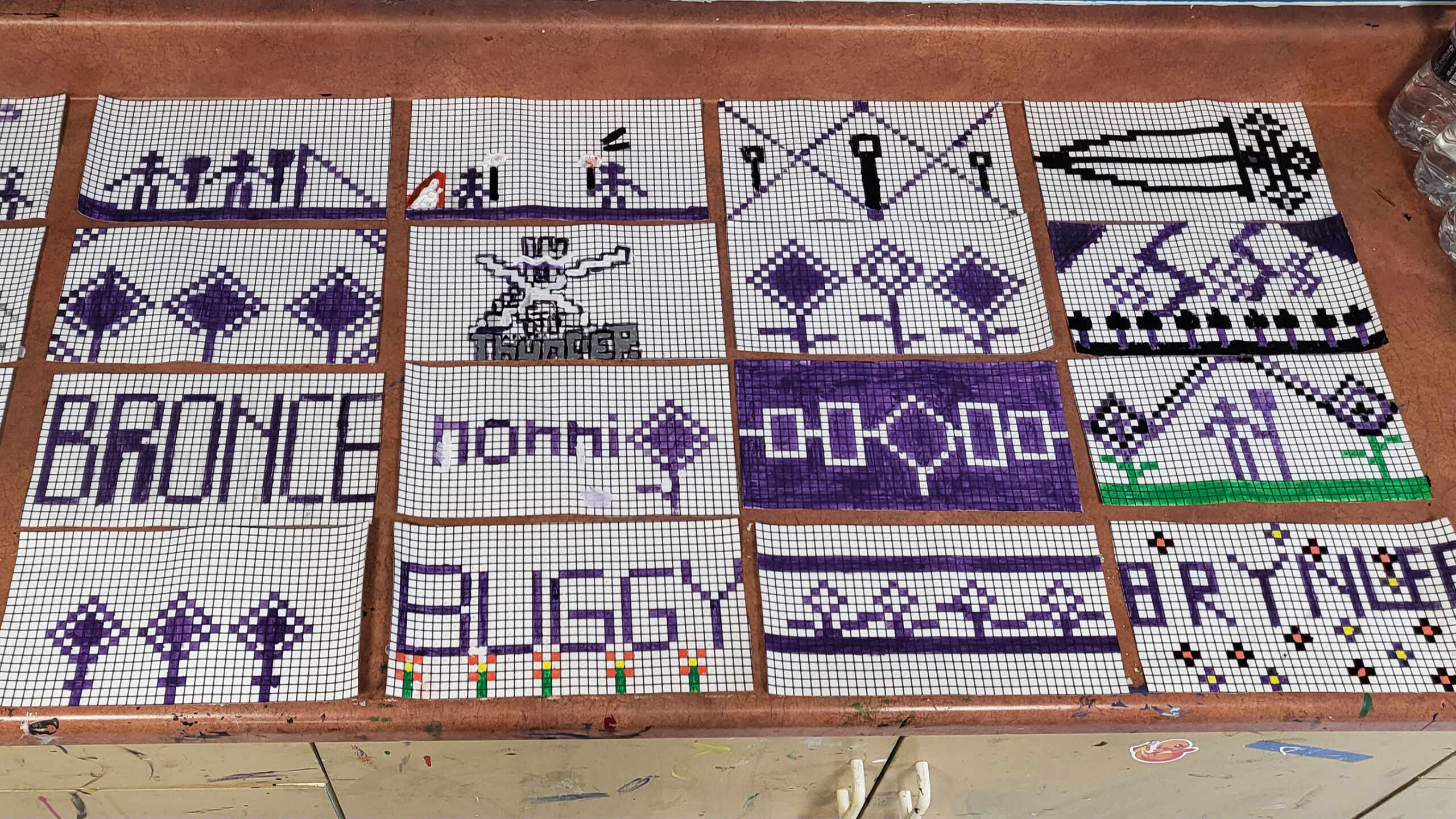 A collection of rectangular panels with intricate designs made from small colored beads is arranged on a wooden surface. The panels feature various patterns and...